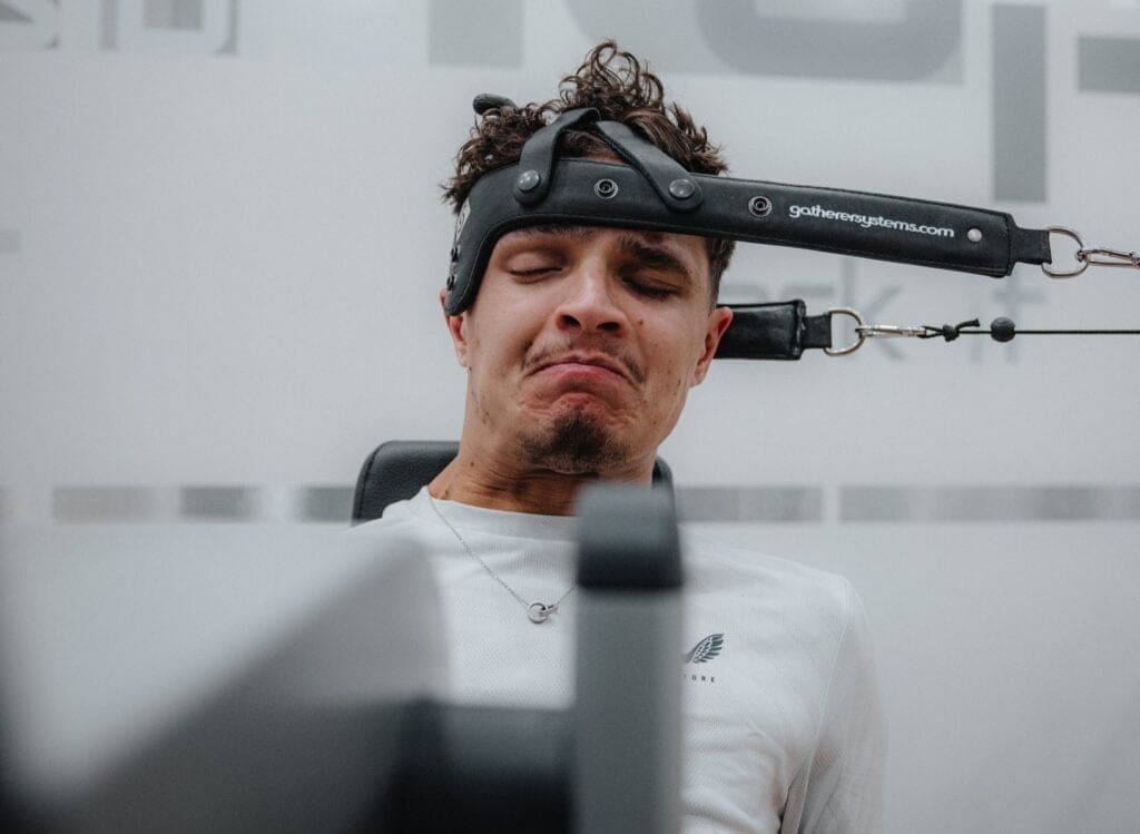 I retroscena della F1: Lando Norris mentre allena la resistenza dei muscoli del collo