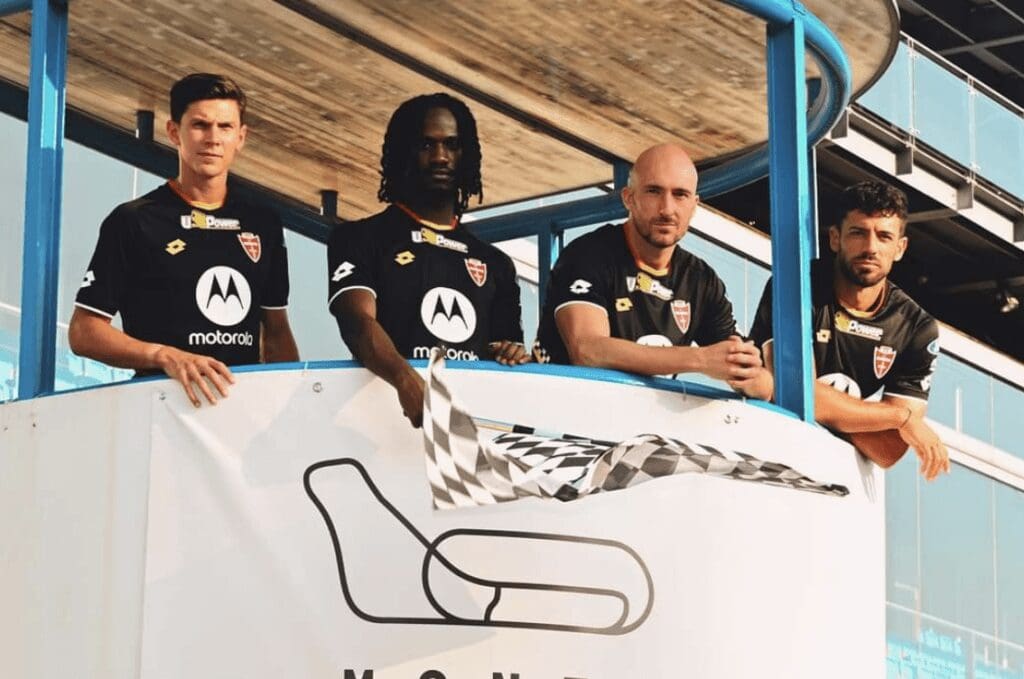 I giocatori del Monza con la bandiera a scacchi: nella foto anche il capitano Matteo Pessina